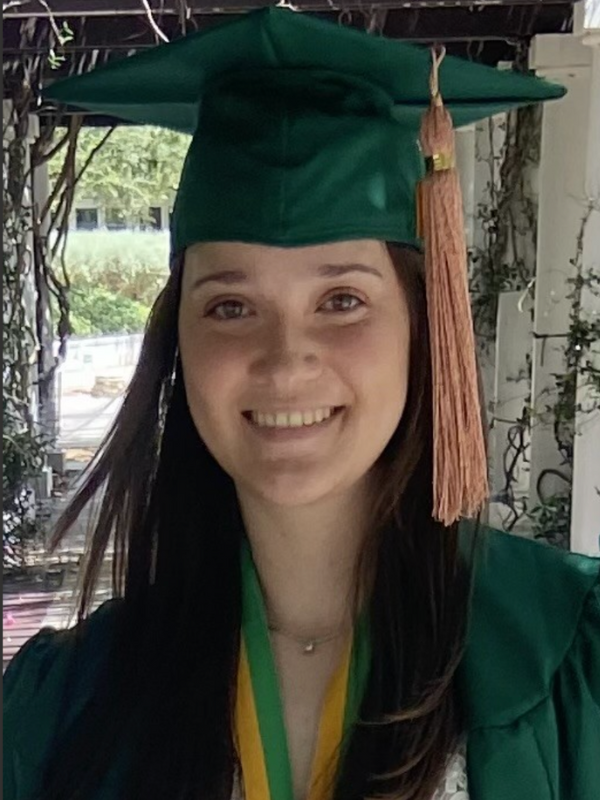 Headshot of Haylie Corcho posed in front of greenery