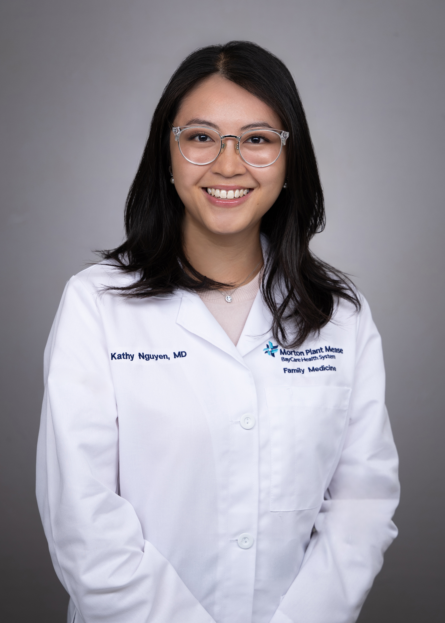 Kathy Nguyen smiling wearing a medical white coat