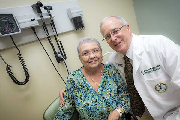 doctor and patient in medical examination room smiling at camera