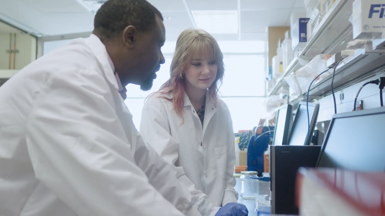 A student and professor in a lab