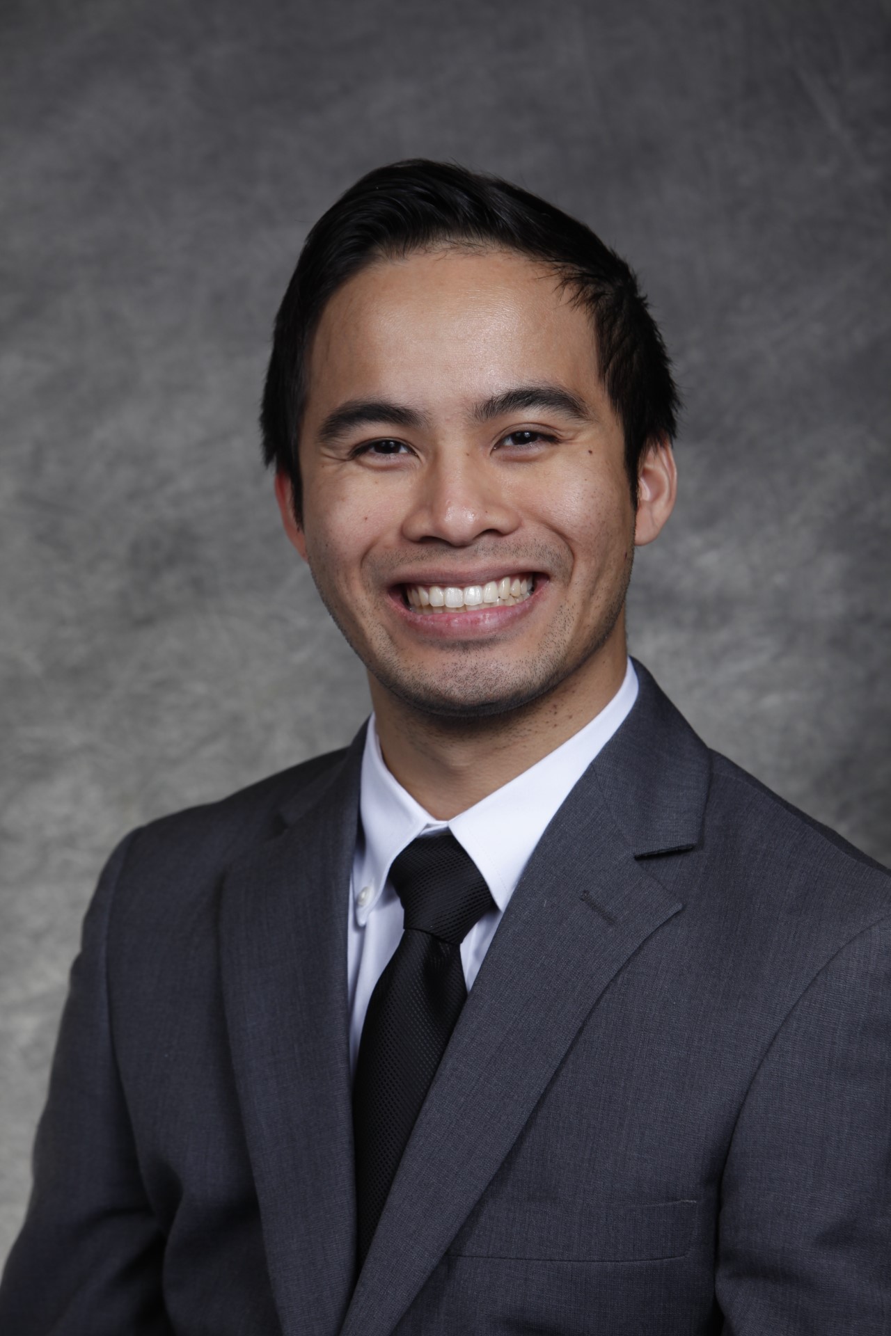 headshot of Nguyen in suit with tie