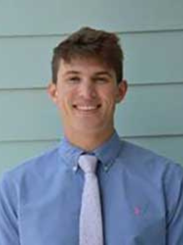 Headshot of Shane Skibba in front of a blue backdrop