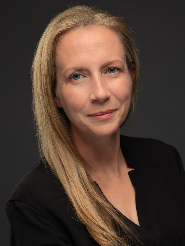 Headshot of Christine McGuire-Wolfe in front of a dark background