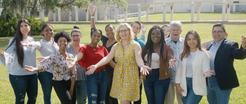 A group of faculty and staff from the USF Center of Excellence in MCH posing and smiling together with excited expressions.