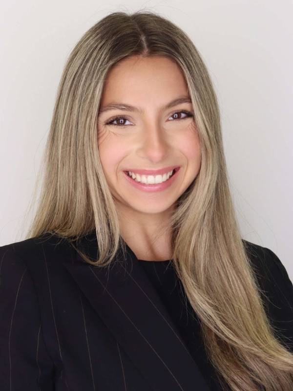 Headshot of Chandler McKnight smiling in front of a grey backdrop.