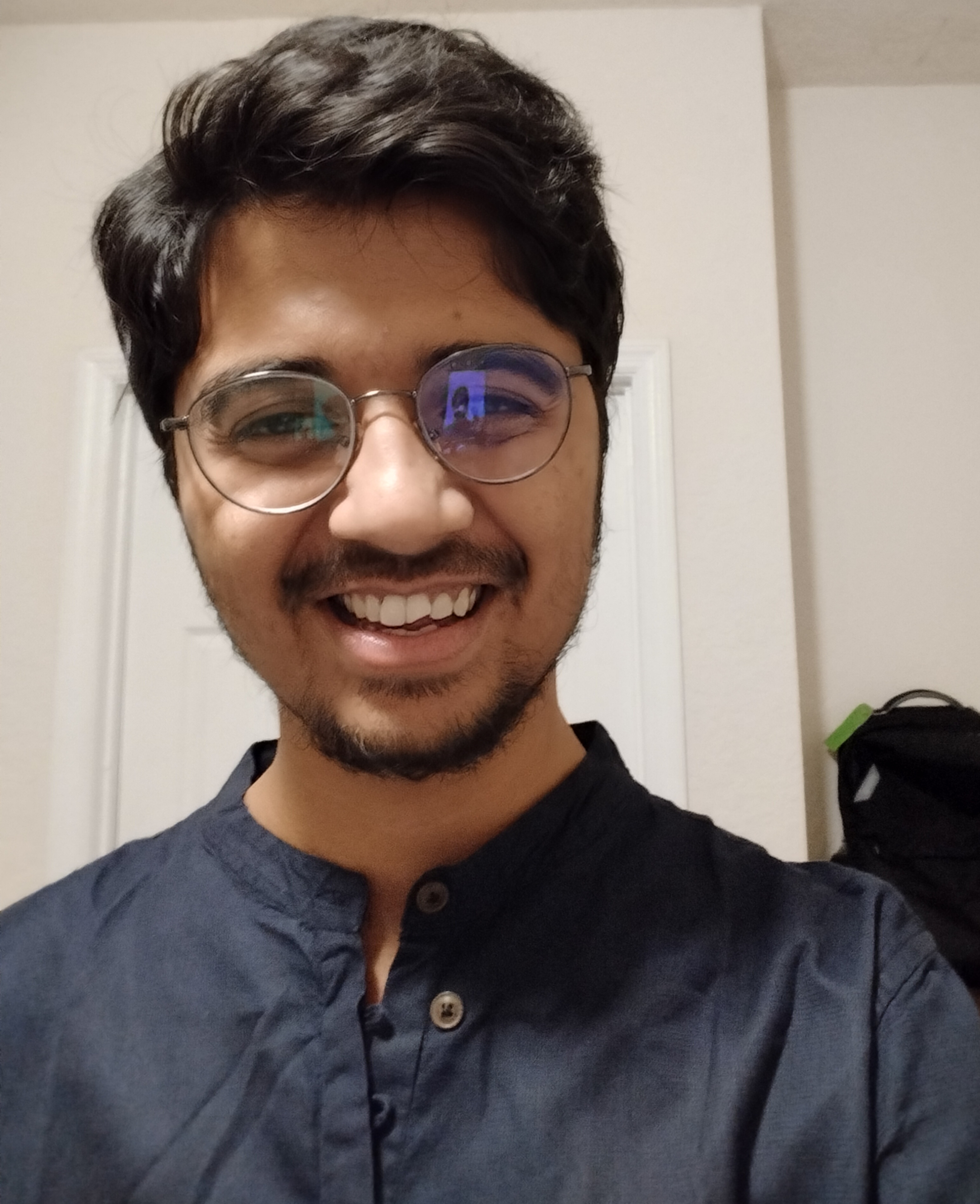 Rajarshi Sakar smiling for a selfie wearing a navy blue button down shirt