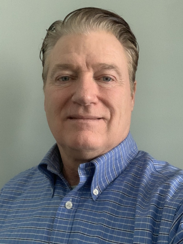 A headshot of Merrill Emfinger in front of a grey backdrop