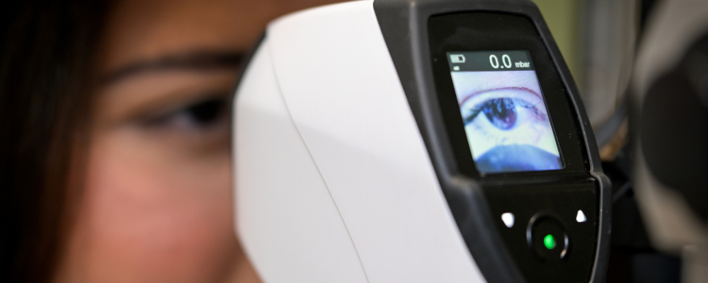 woman getting an eye exam with exam instrument 