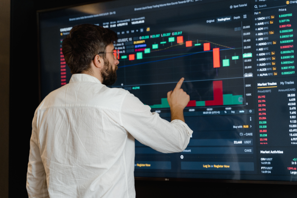 A person pointing at a chart on a large screen