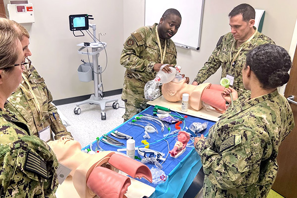 Military personal performing medical training on training manikins. 