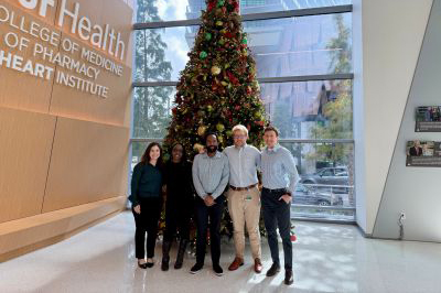 Heart Institute administration in front of USF Health Christmas tree at the Morsani College of Medicine Channelside building