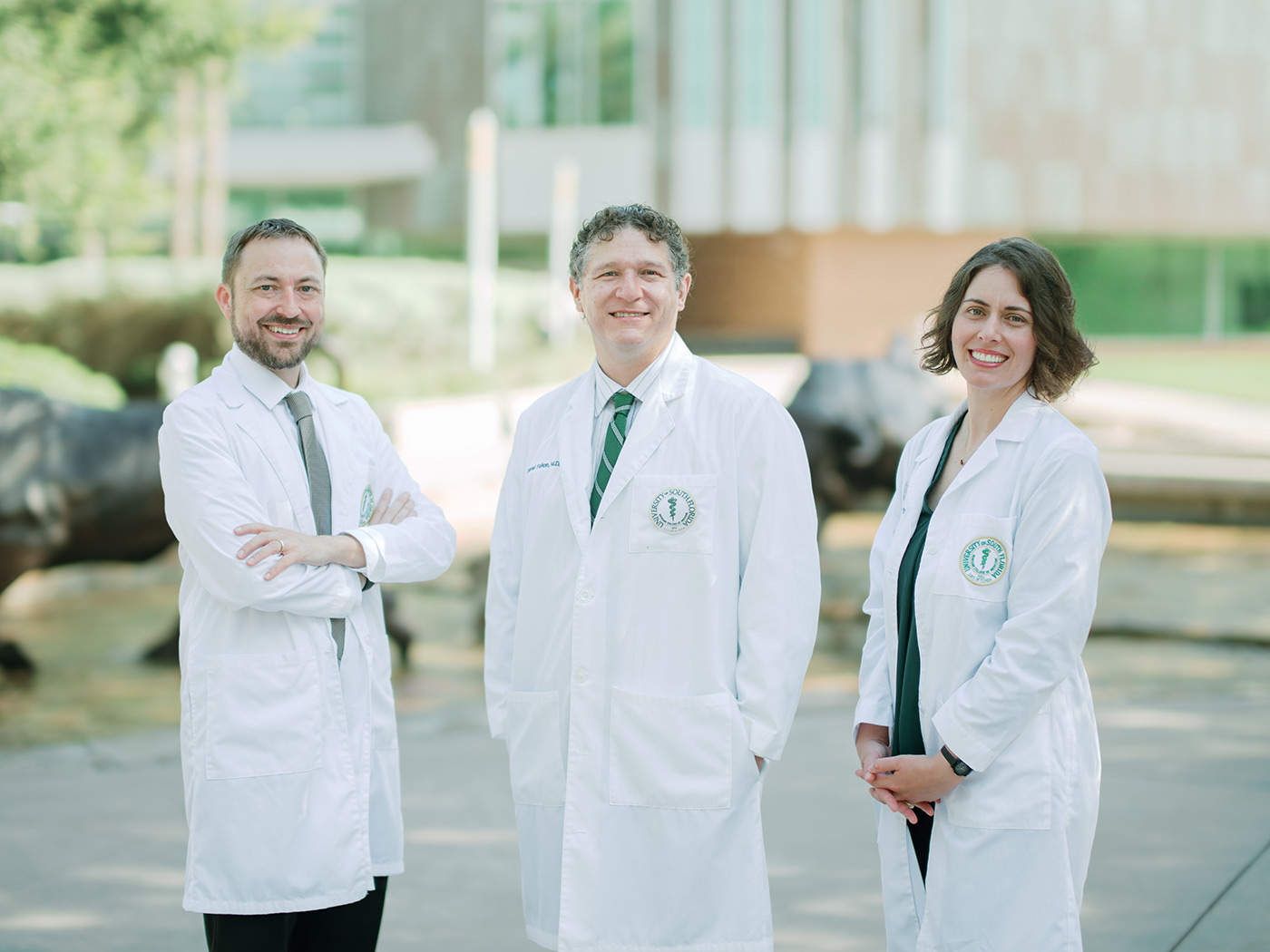 Group of three doctors outside USF medical facilities. 