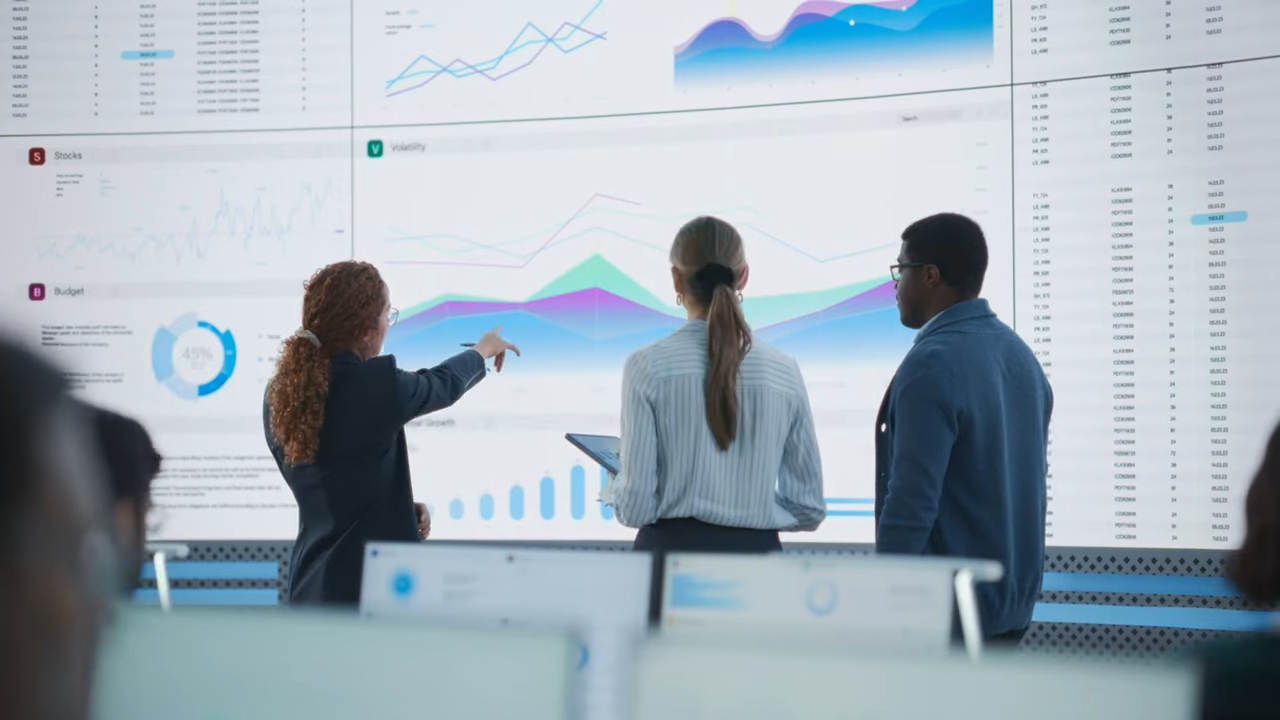 A group of people analyzing data on a projected screen