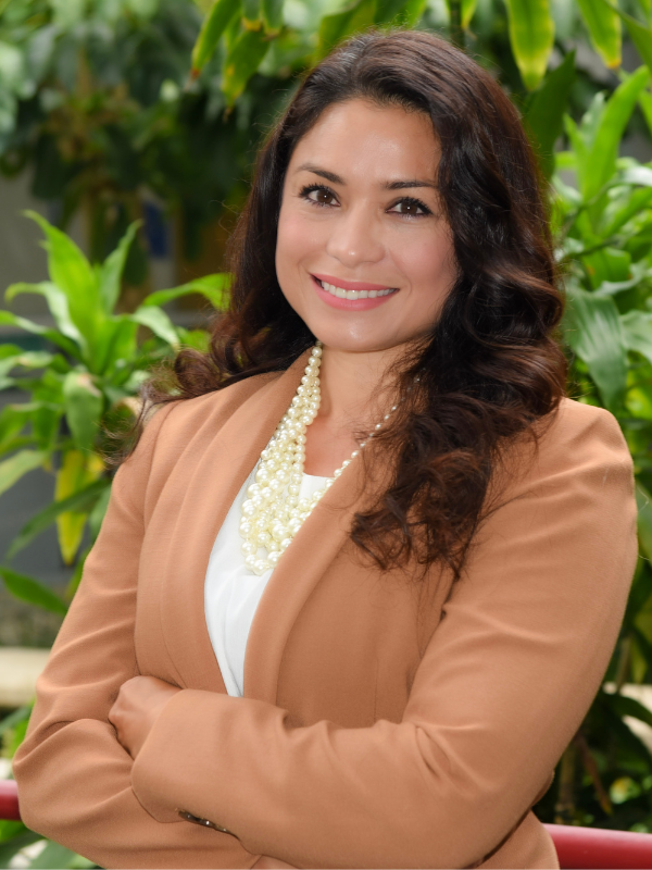 Headshot of Ann Joyce in front of greenery
