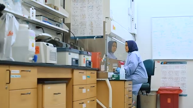 A woman sitting at a desk in a lab setting