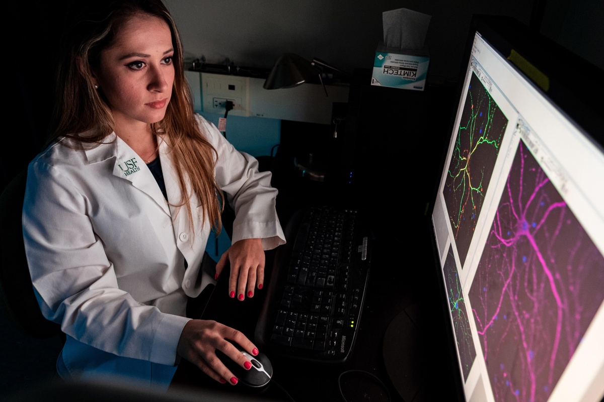 Medical professional in a white coat looks at a computer screen