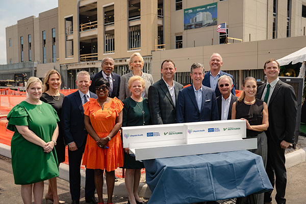 Group photo: Florida House Speaker Paul Renner, Senator Jim Boyd, who championed the legislation, and Senator Darryl Rouson, who co-sponsored the legislation, joined John Couris, president and CEO of Tampa General; Rhea Law, president of USF; City of Tampa Mayor Jane Castor; Dr. Charles Lockwood, executive vice president of USF Health and dean of the USF Health Morsani College of Medicine; Dr. Ryan Wagoner, chair, Department of Psychiatry and Behavioral Neurosciences at the USF Health Morsani College of Medicine; Marty Mann, chief development officer, Lifepoint Health; and Kathy Bolmer, chief operating officer, Lifepoint Health; at the site where the TGH Behavioral Health Hospital is presently under construction