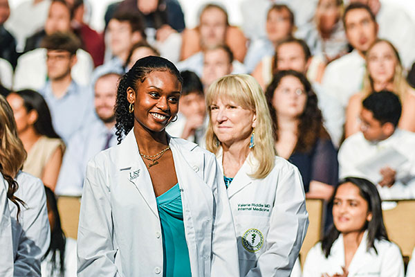 Photo of medical students in a crowd, centered on two women