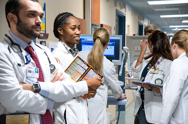 A group of medical trainees together in a hospital hallway