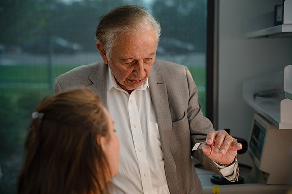 Photo of Dr. Robert C. Gallo, speaking with a woman