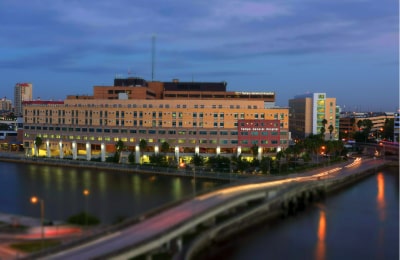 Waterfront view of Tampa General Hospital at sunset.